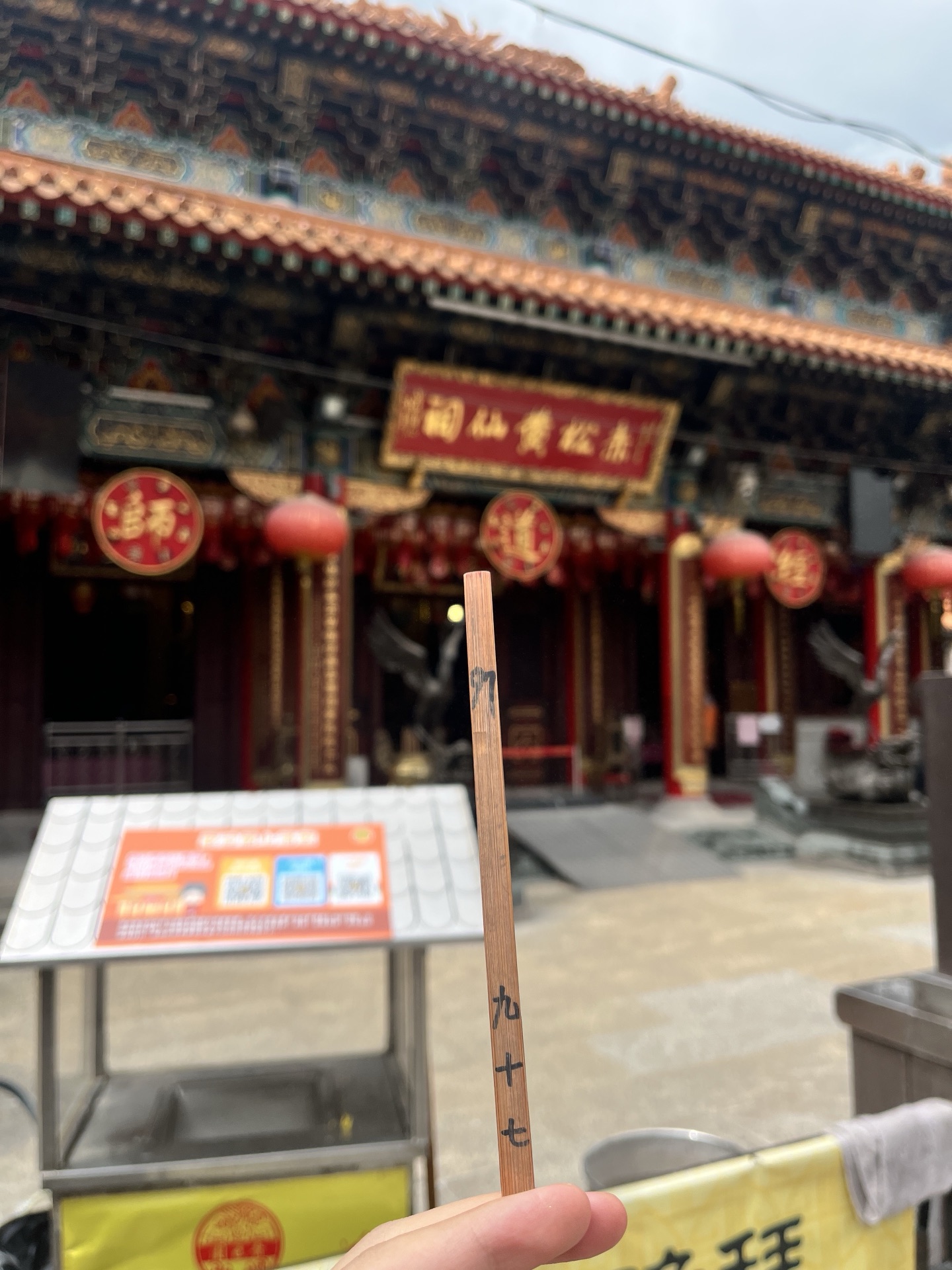創辦人喺黃大仙祠前手持籤枝嘅實拍記錄
